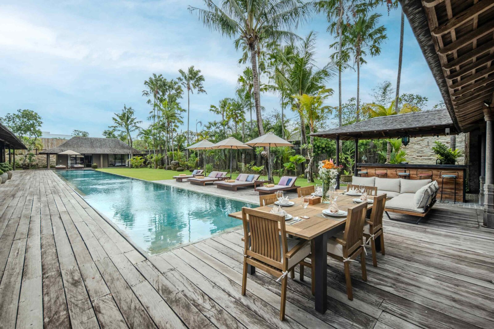 The outdoor dining table on the deck beside the pool