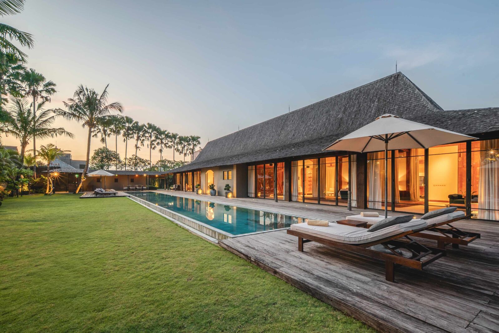 The villa, pool and lawn at sunset