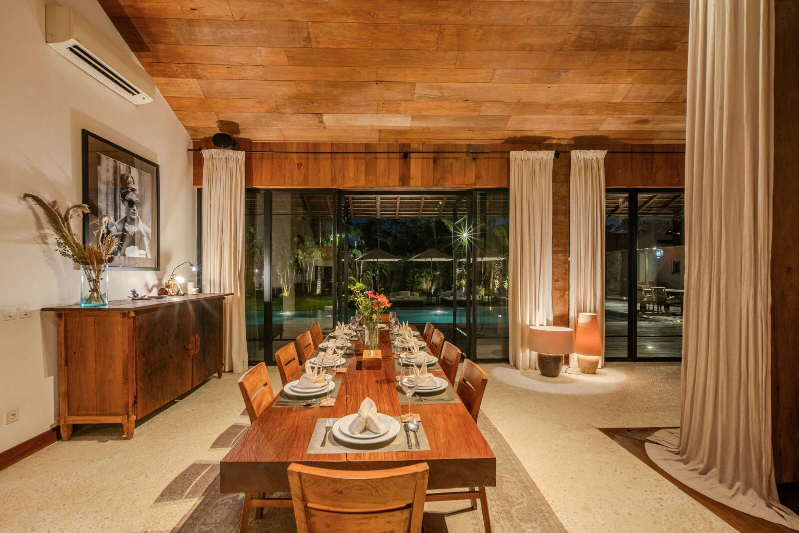 The teak dining table laid for ten