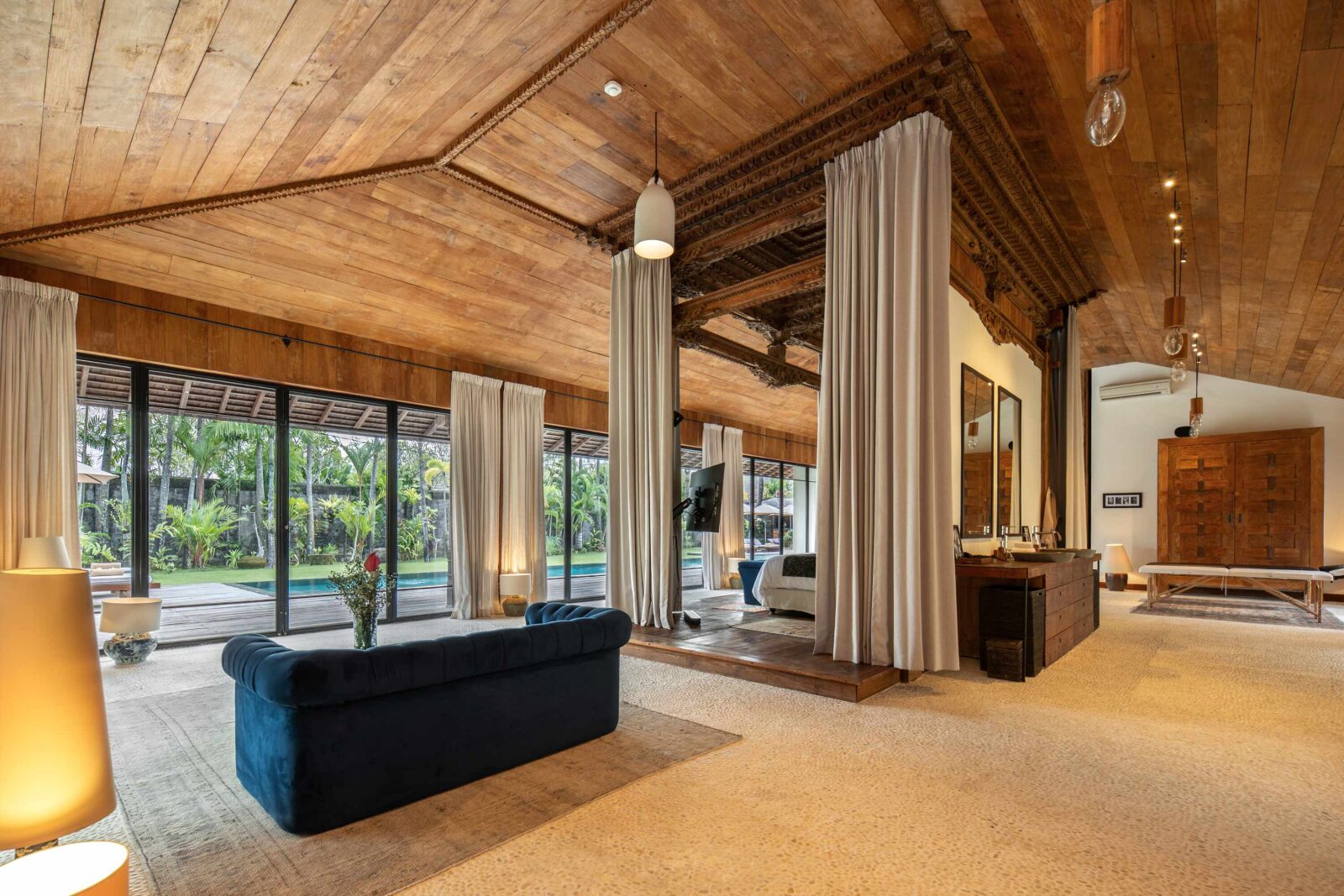 The master suite lounge, open to the pool through a full glass wall