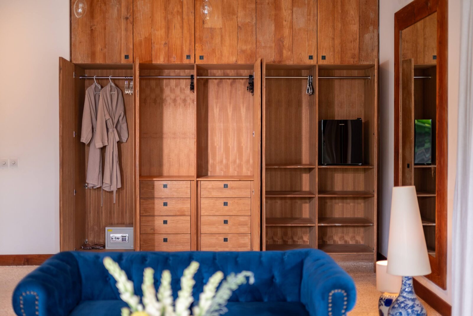 The master suite's wall of teak wardrobes with robes hanging ready
