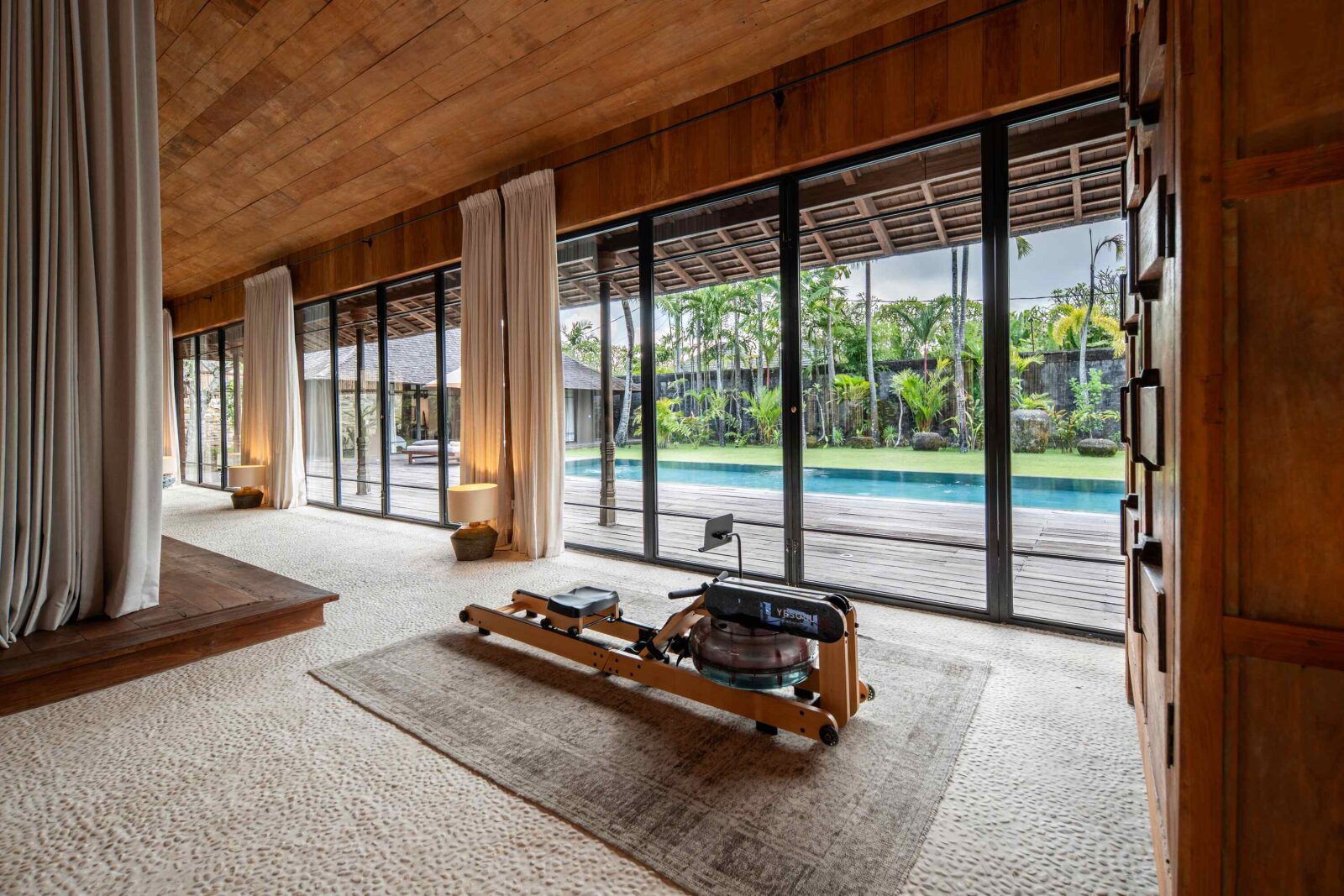 Exercise equipment in the master suite, looking out to the pool