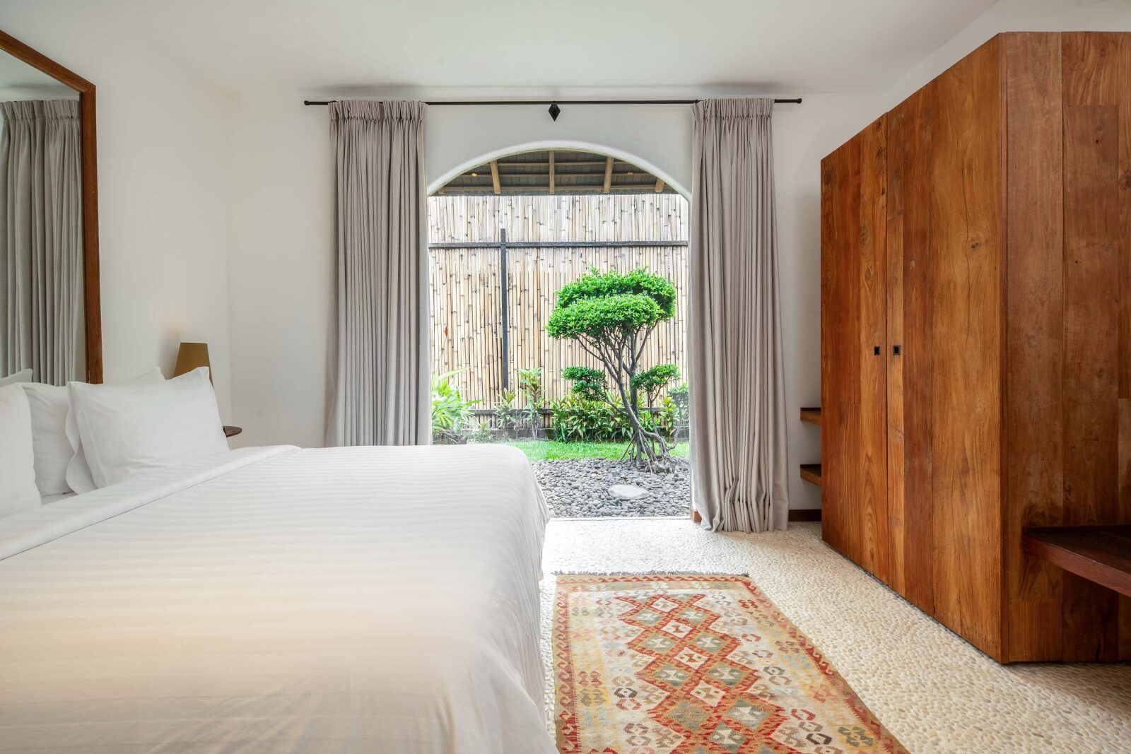 The garden-view bedroom, its bed beside doors onto the planted courtyard