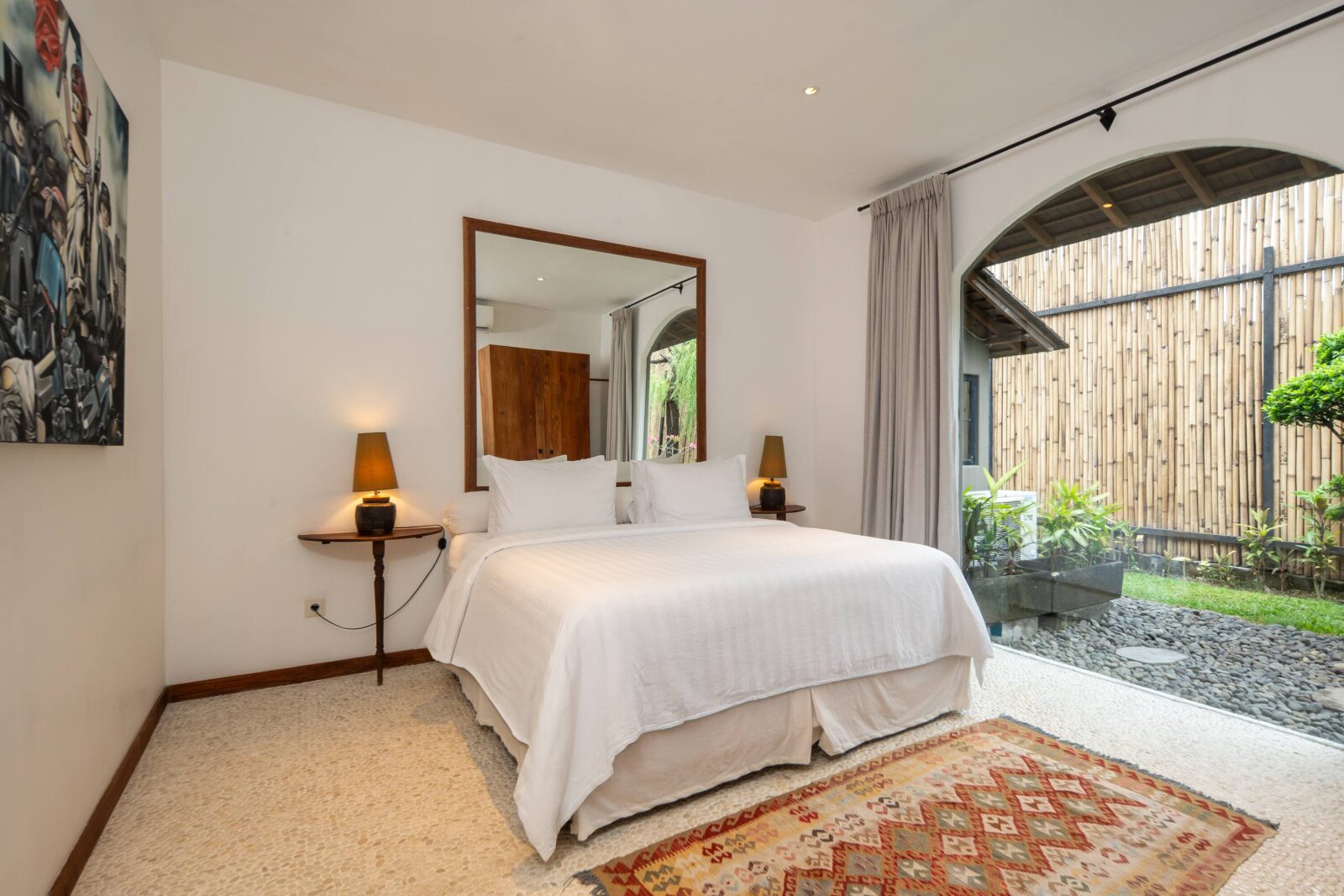 The garden-view bedroom, looking out through its arched window