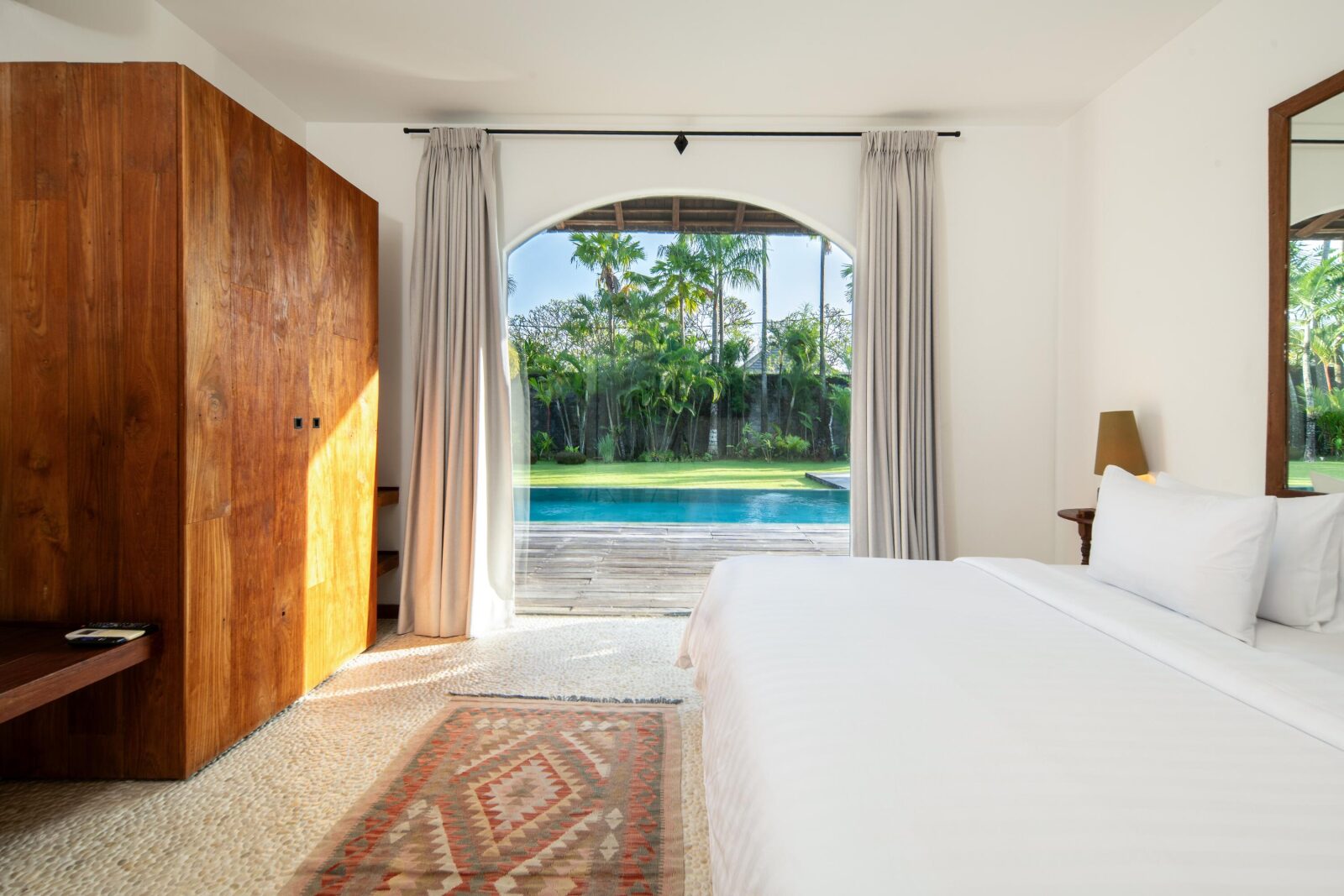 The pool-view bedroom's wardrobe, with the pool beyond the glass